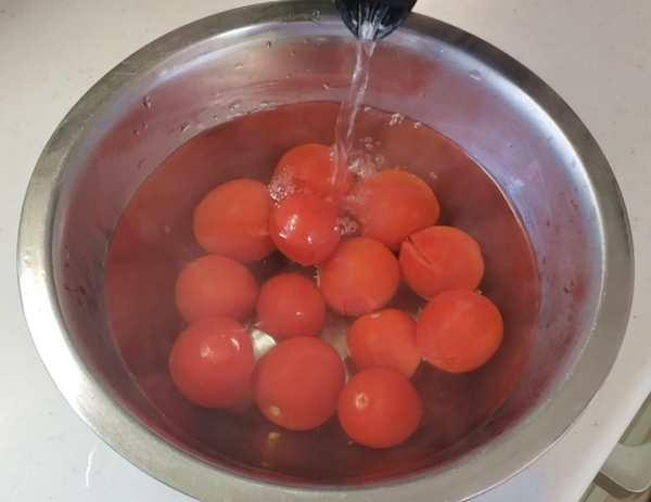 トマトにお湯を注いでいる様子