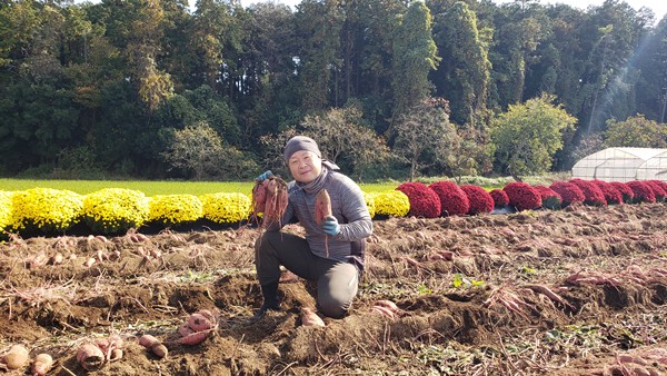さつまいもを持った4代目園主-2025